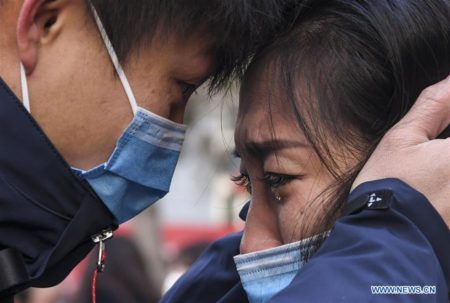 Lyu Jun (e), membro de uma equipe médica que parte para Wuhan, na província de Hubei, se despede de sua família na Universidade Médica de Xinjiang, em Urumqi, região autônoma de Xinjiang Uygur, noroeste da China, em 28 de janeiro de 2020 (Xinhua / Wang Fei)