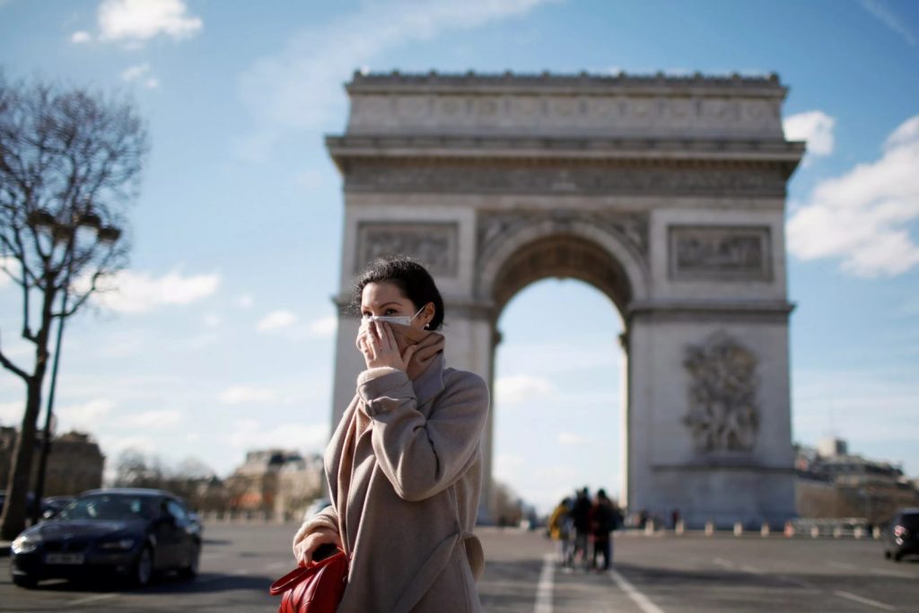 Mulher usa máscara de proteção enquanto caminha em Paris, na França - Foto: Reuters