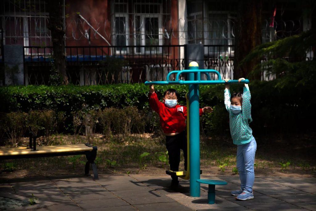 Crianças com máscara brincam em parque de Pequim — Foto: Mark Schiefelbein/AP