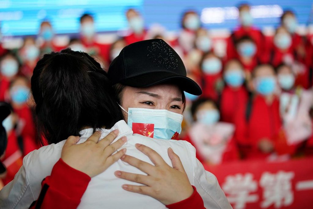 Agente de saúde se emociona ao abraçar colega após fim de isolamento em Wuhan Foto: Aly Song/Reuters
